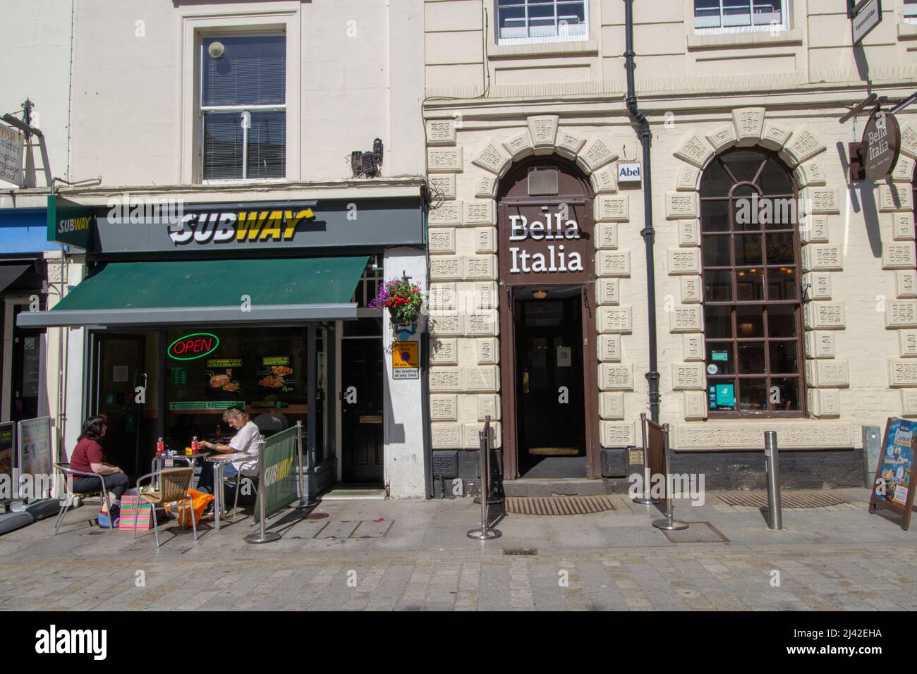 EXETER, UK - JULY 18, 2021 branches of Subway fast food restaurant and Bella Italia Italian restaurant on Queen Street Stock Photo