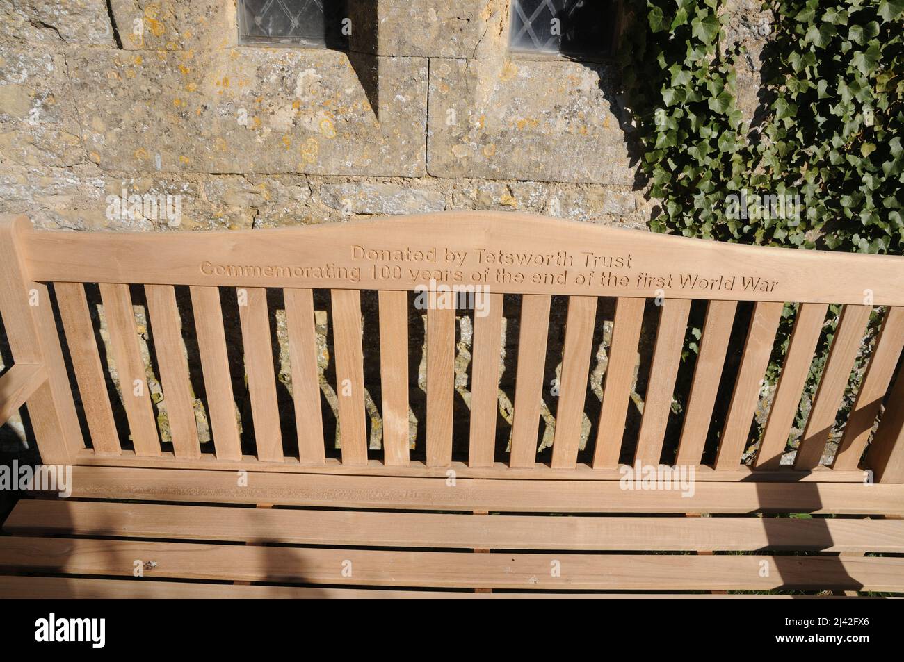 Memorial Bench in churchyard of St Giles Church, Tetsworth, Oxfordshire Stock Photo