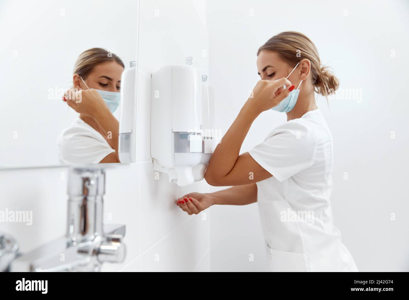 Surgeon washing hands before operating in hospital. Health care and hygiene concept Stock Photo