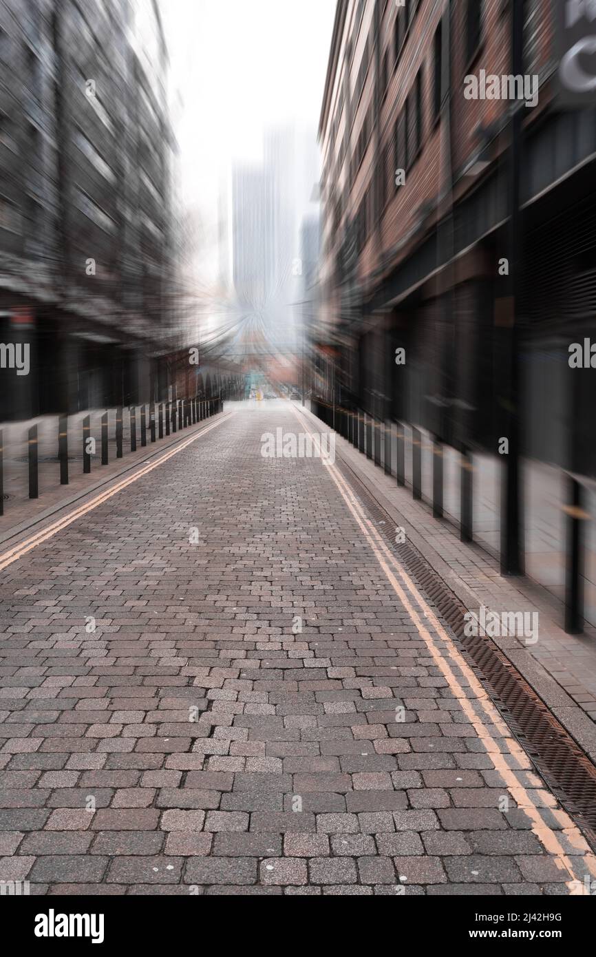 Manchester city center back street cobbled sets zooming into distance blue effect Stock Photo
