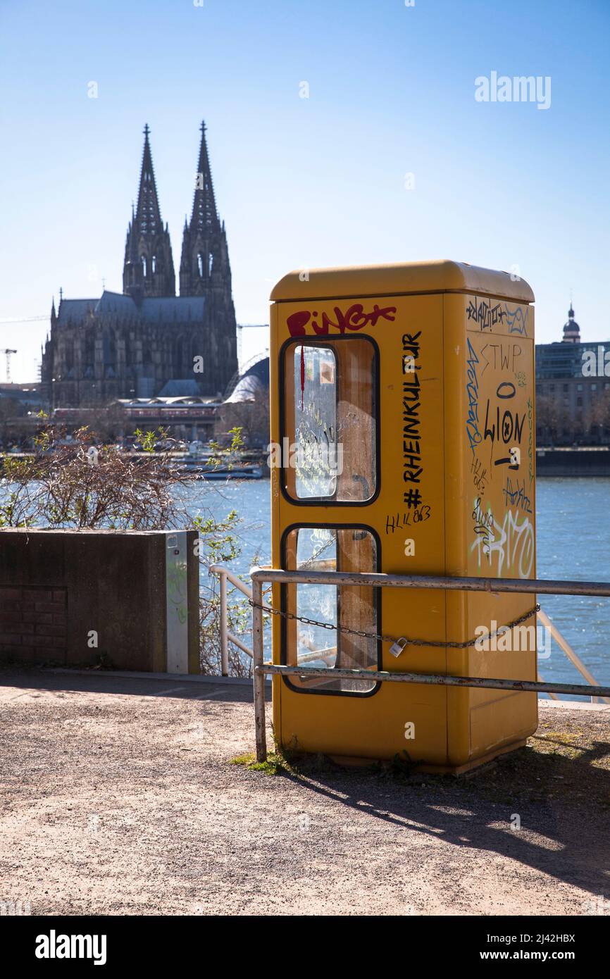an old telephone box stands on the banks of the Rhine in the district Deutz, view to the cathedral, Cologne, Germany. eine alte Telefonzelle steht am Stock Photo