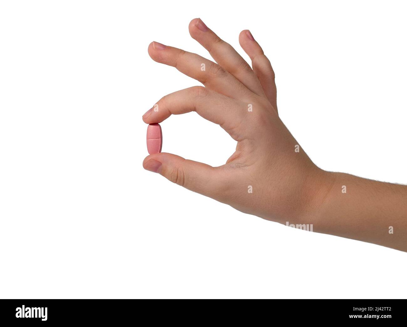 Large oval pill with dosed division in two fingers an elegant hand. Isolated on a white background. Stock Photo