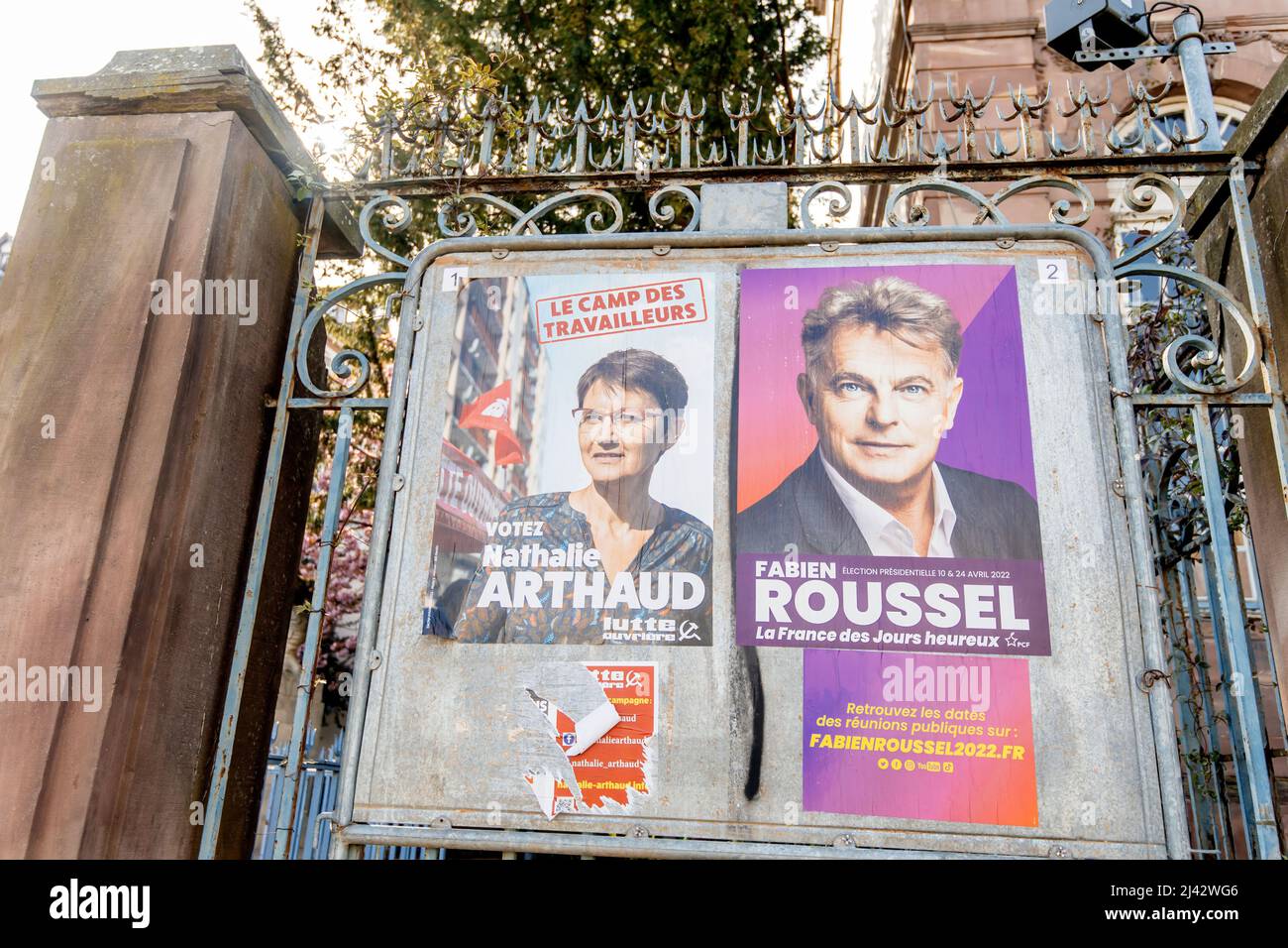 STRASBOURG, FRANCE - APR 23, 2022: French presidential posters for the upcoming presidential election in France, in front of the City Hall building in Strasbourg featuring Nathalie Arthaud and Fabien Roussel Stock Photo