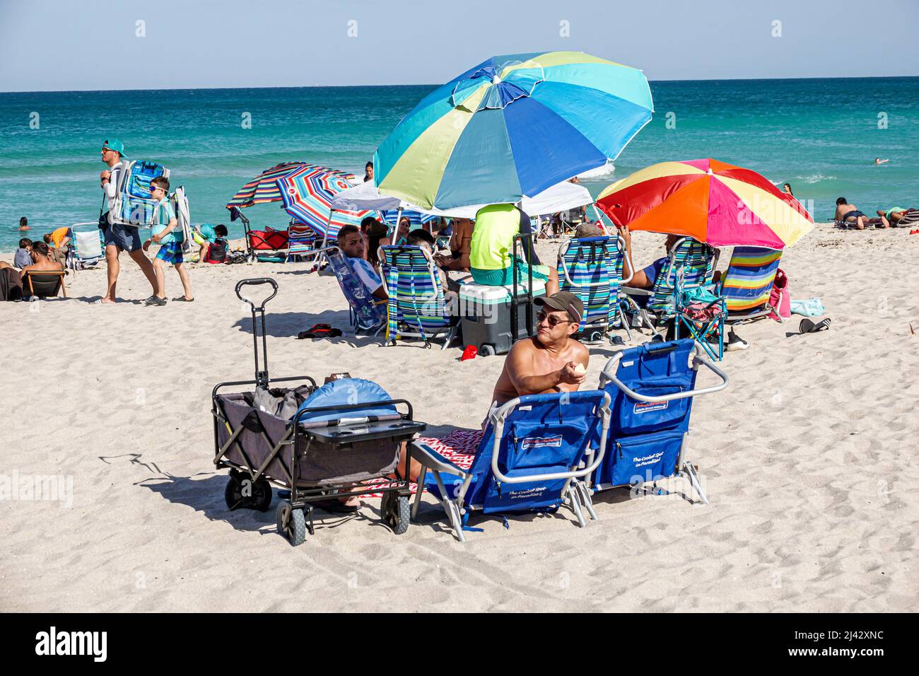 Miami Beach Florida public North Beach sunbathers Atlantic Ocean Hispanic people families Stock Photo