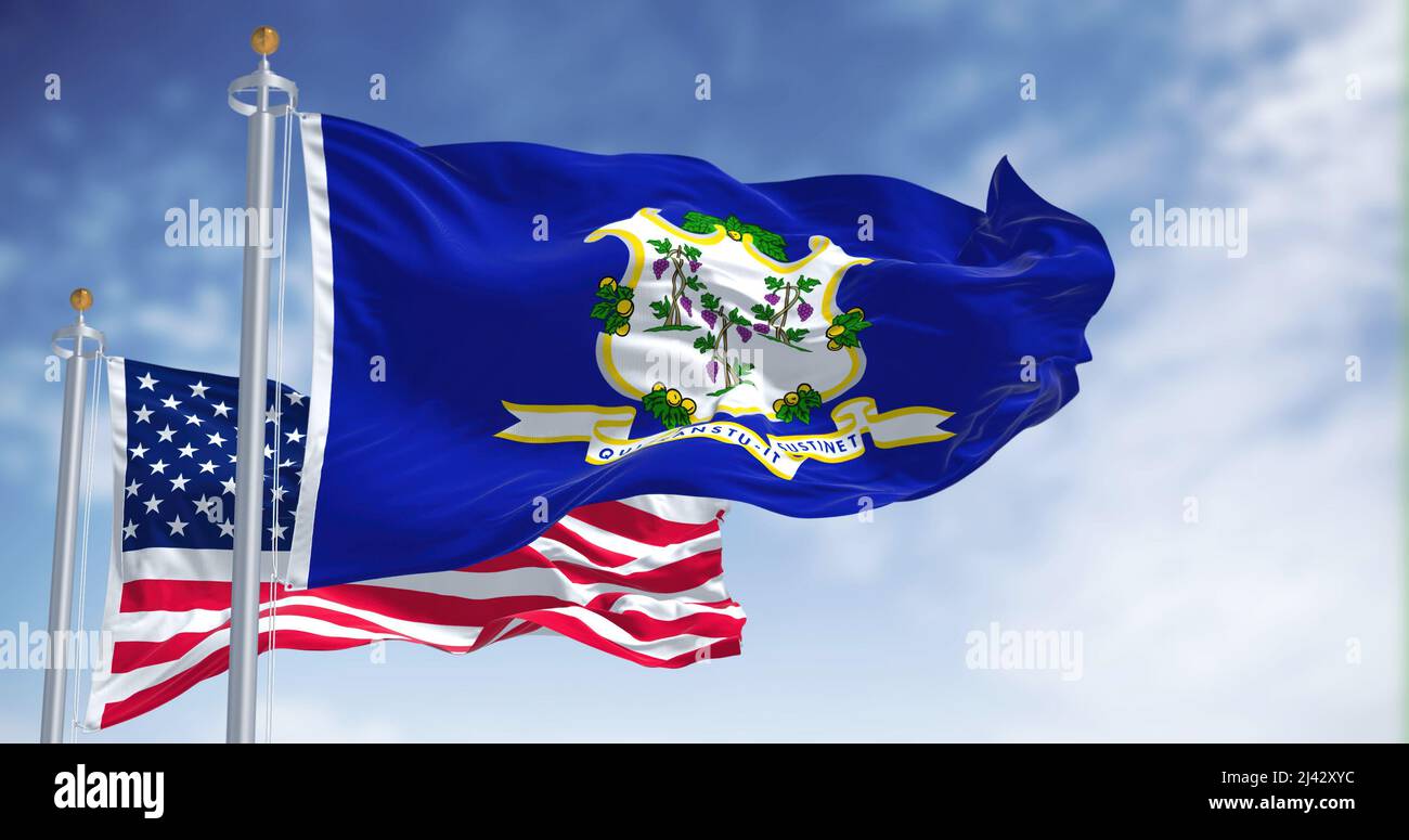 The Connecticut state flag waving along with the national flag of the United States of America. In the background there is a clear sky. Stock Photo