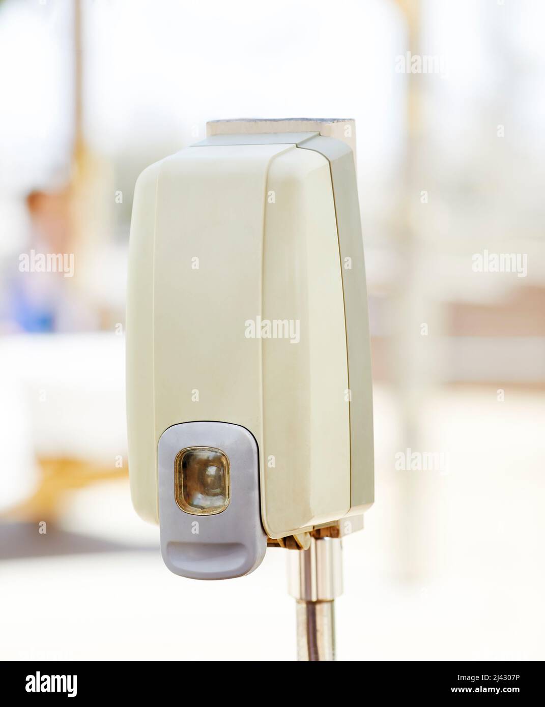 Hand Sanitizer dispenser installed outdoors with shallow depth of field Stock Photo