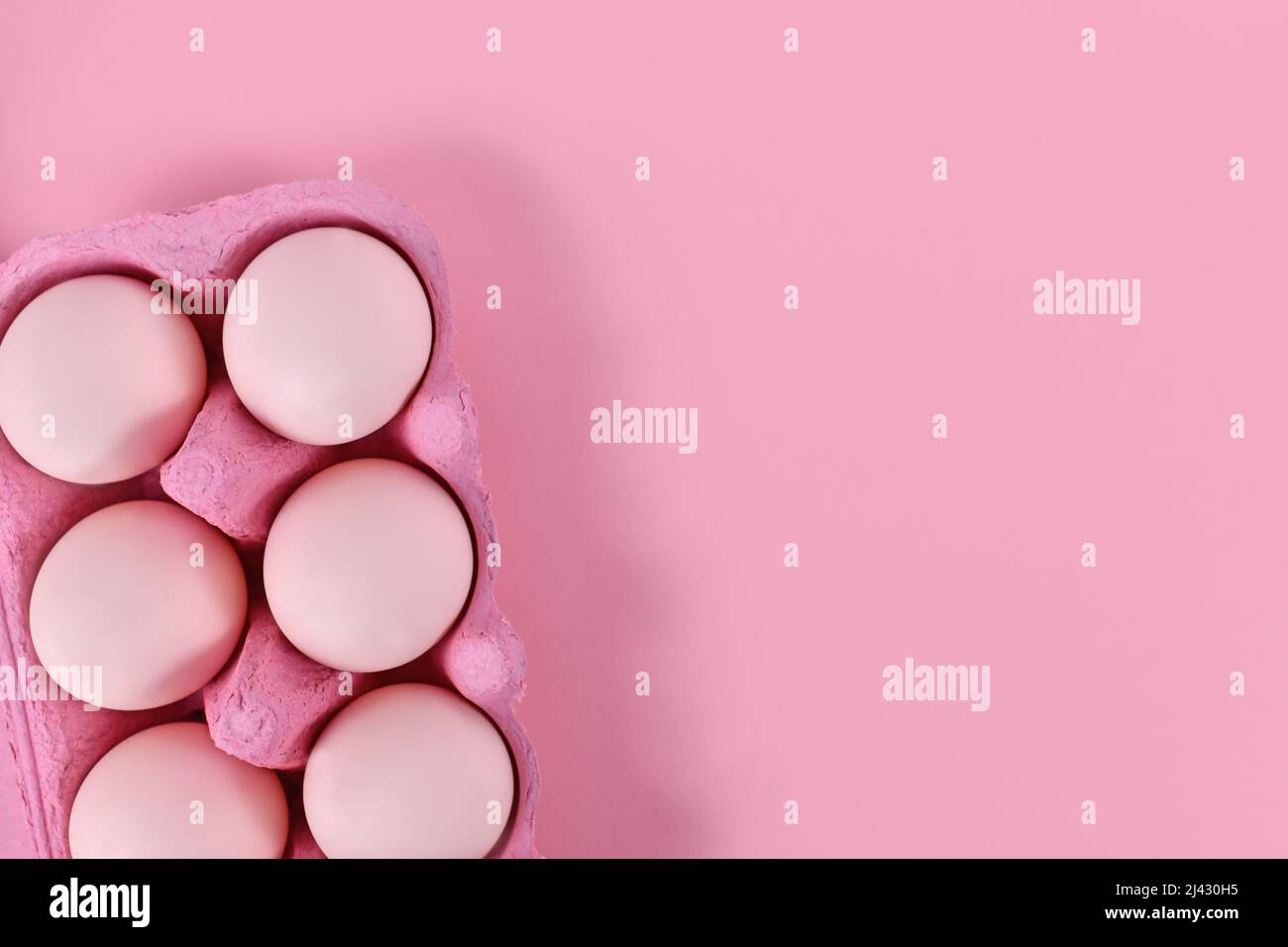 Easter eggs in box on pink background with copy space Stock Photo