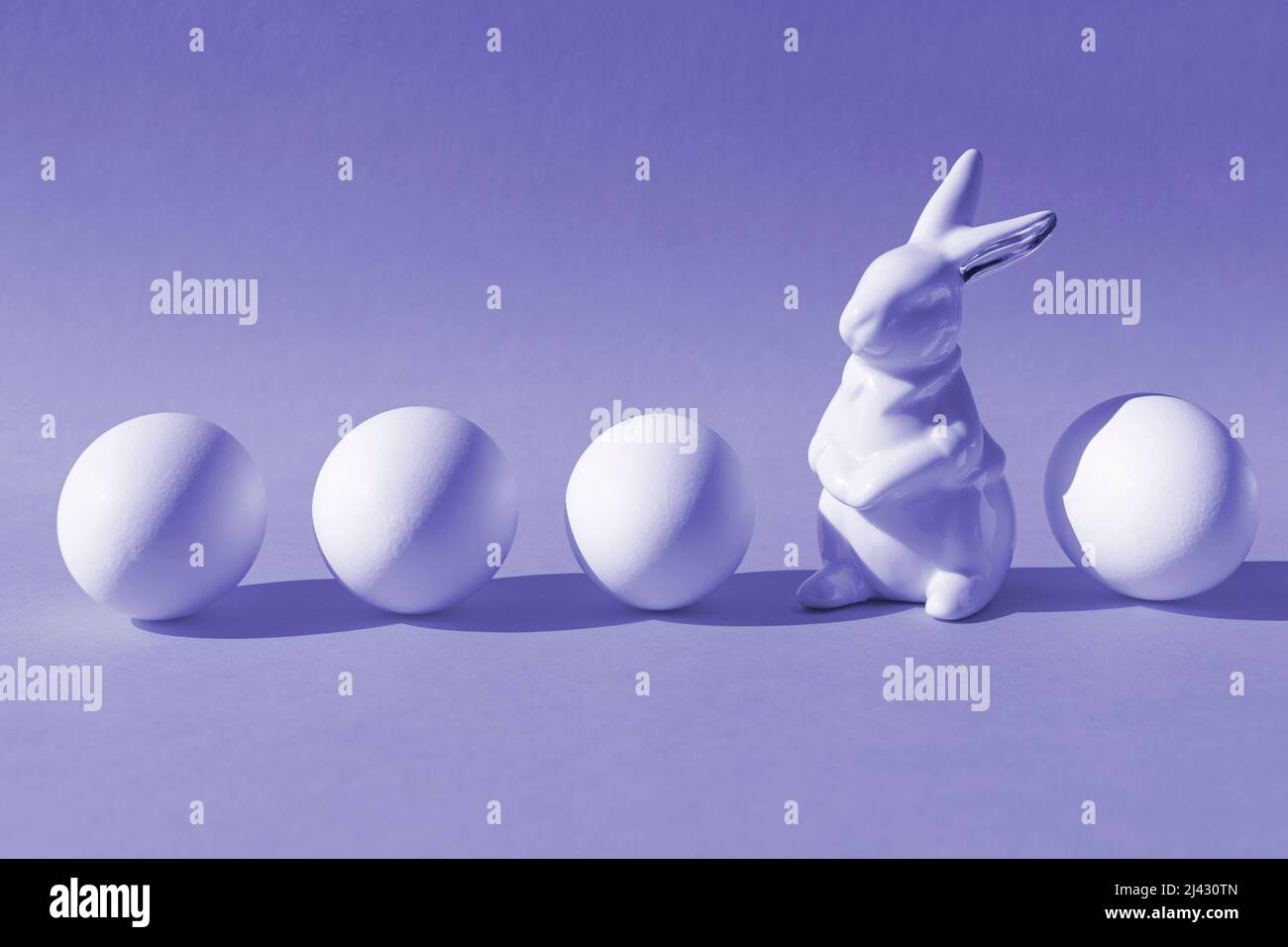 Creative minimalist Easter concept. Porcelain rabbit with four eggs. Trendy colors of 2022. Copy space. Stock Photo