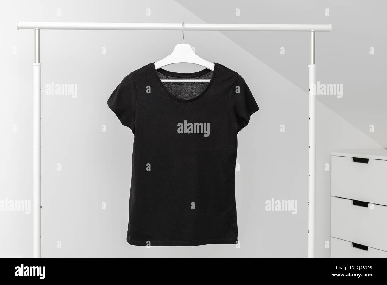 T-shirt hanging on Clothing rack. Round neck Black color. Template, mock up Stock Photo