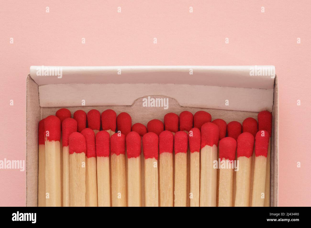 natural wooden matches side by side packed in box on pink background, close-up, flat lay Stock Photo
