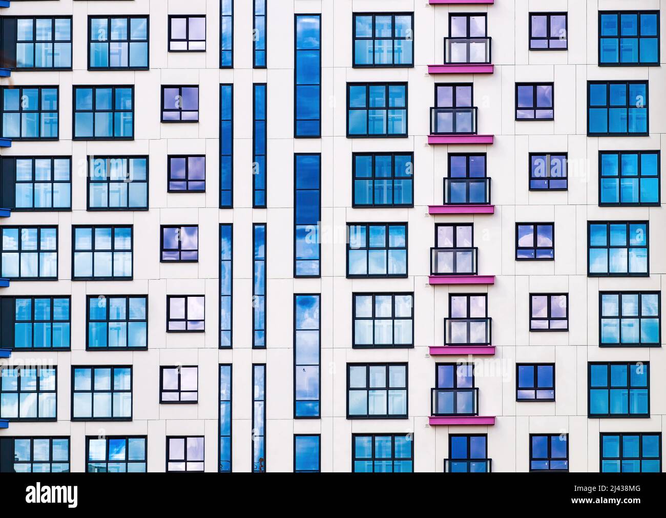 A brightly colored facade of a residential building. Abstract background of colored windows. Stock Photo