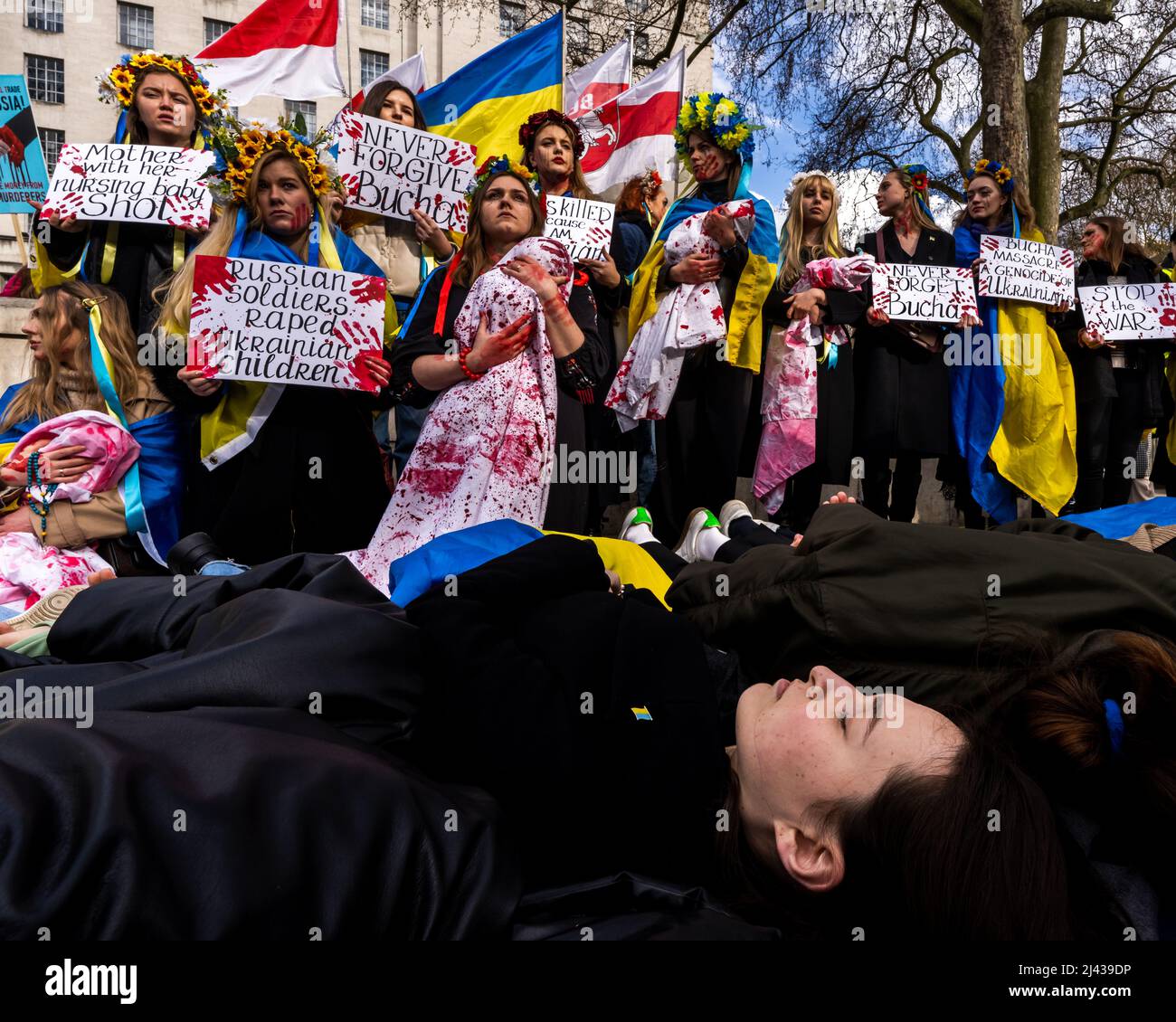 Evening, 9th April. Protesters dressed in traditional Ukrainian clothes, tainted with red paint, to reenact the horror inflicted by the Russian Army. Stock Photo