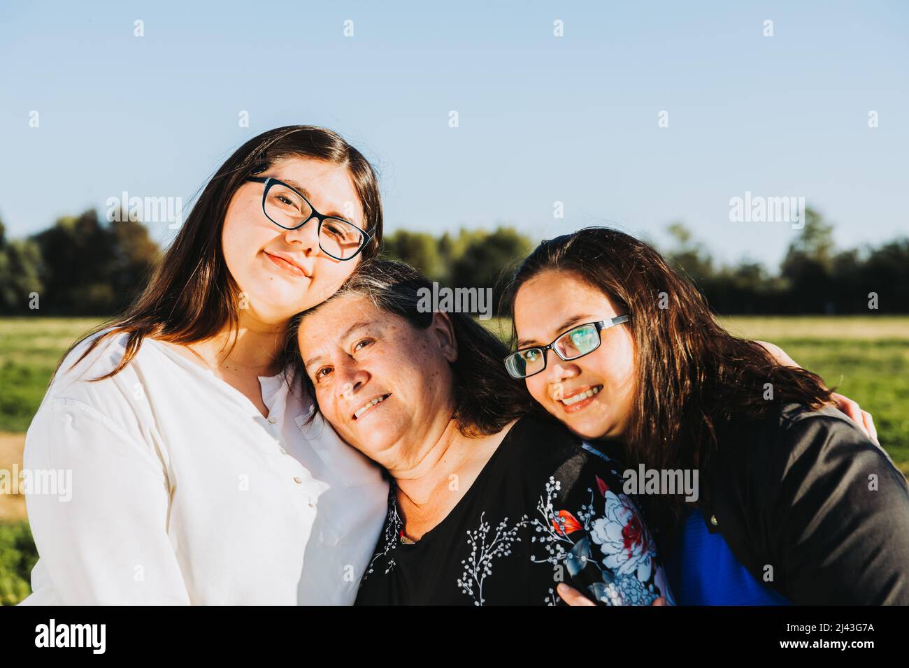 Female Family smiling and hugging in the field on a sunny day afternoon. Mothers day. Stock Photo