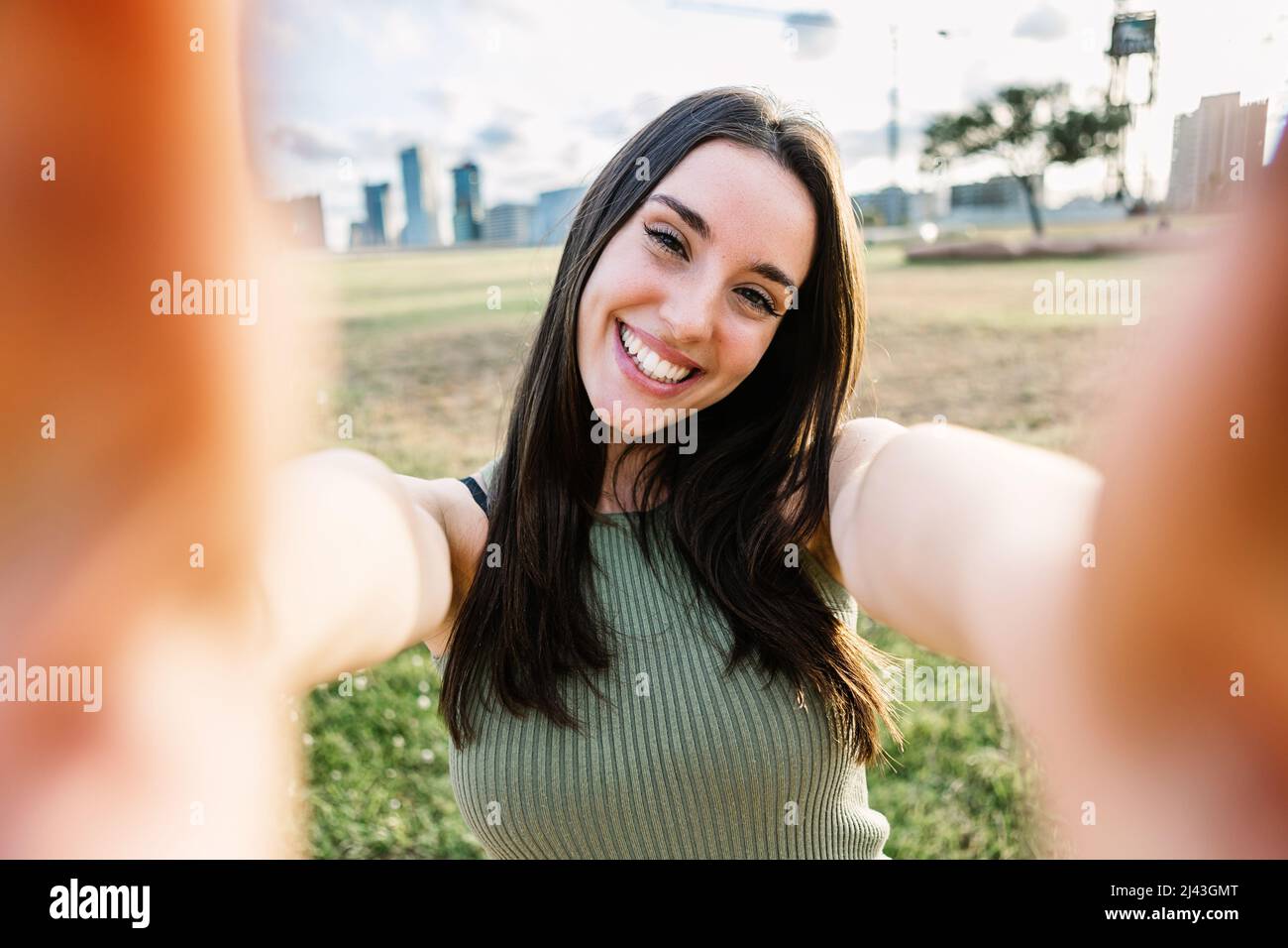 Beautiful young woman taking selfie portrait with cellphone outdoors in summer Stock Photo