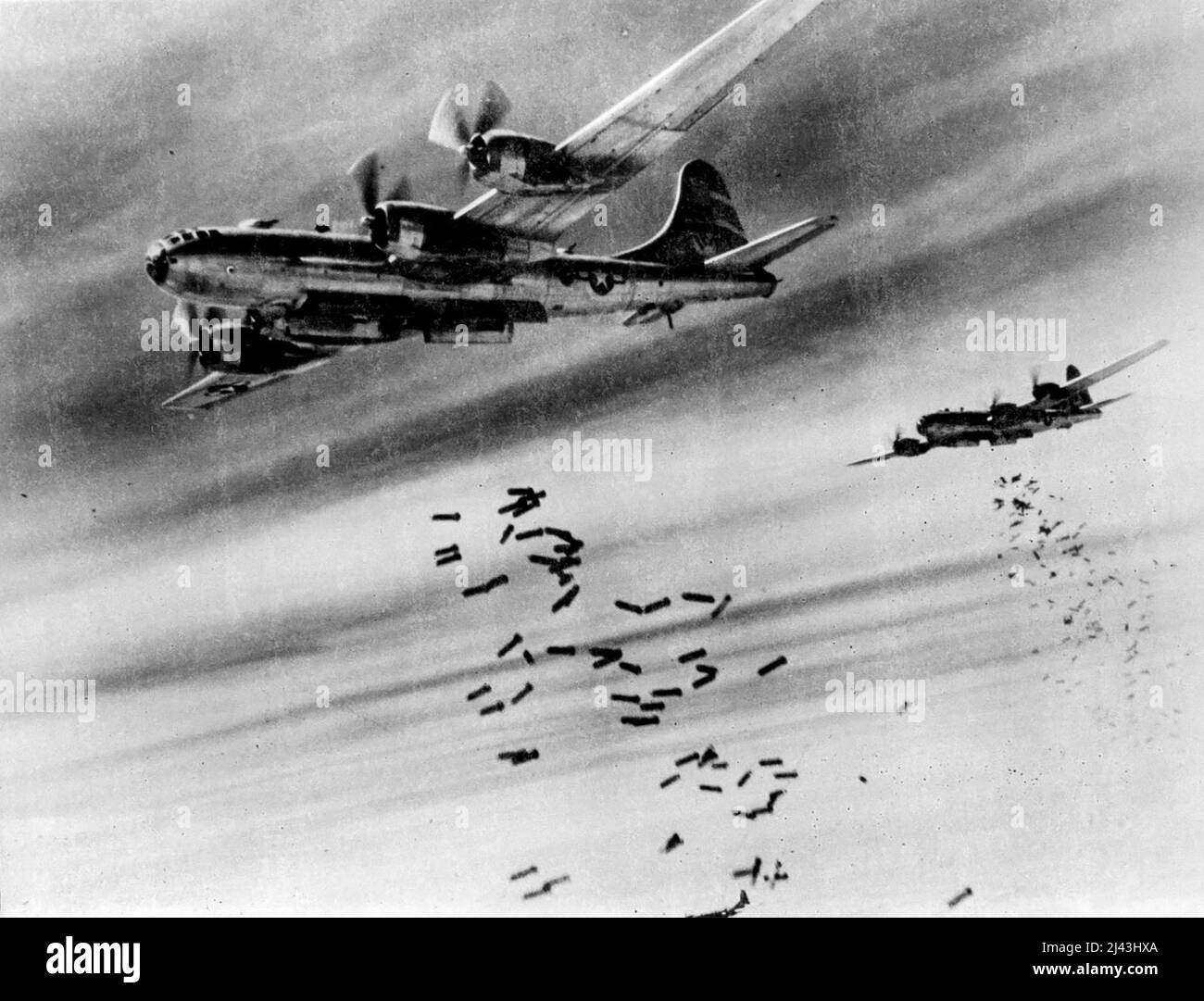 Superfortress Bombs Over Burma. Tons of bombs speckle the sky over Rangoon, Burma, as they spew from the yawning bomb bays of B-29 Superfortresses. The target of this daylight attack by the 20th Bomber Command B-29s was a large Japanese supply depot near the Mingaladon Air Field near Rangoon. January 3, 1945. (Photo by Associated Press Photo). Stock Photo