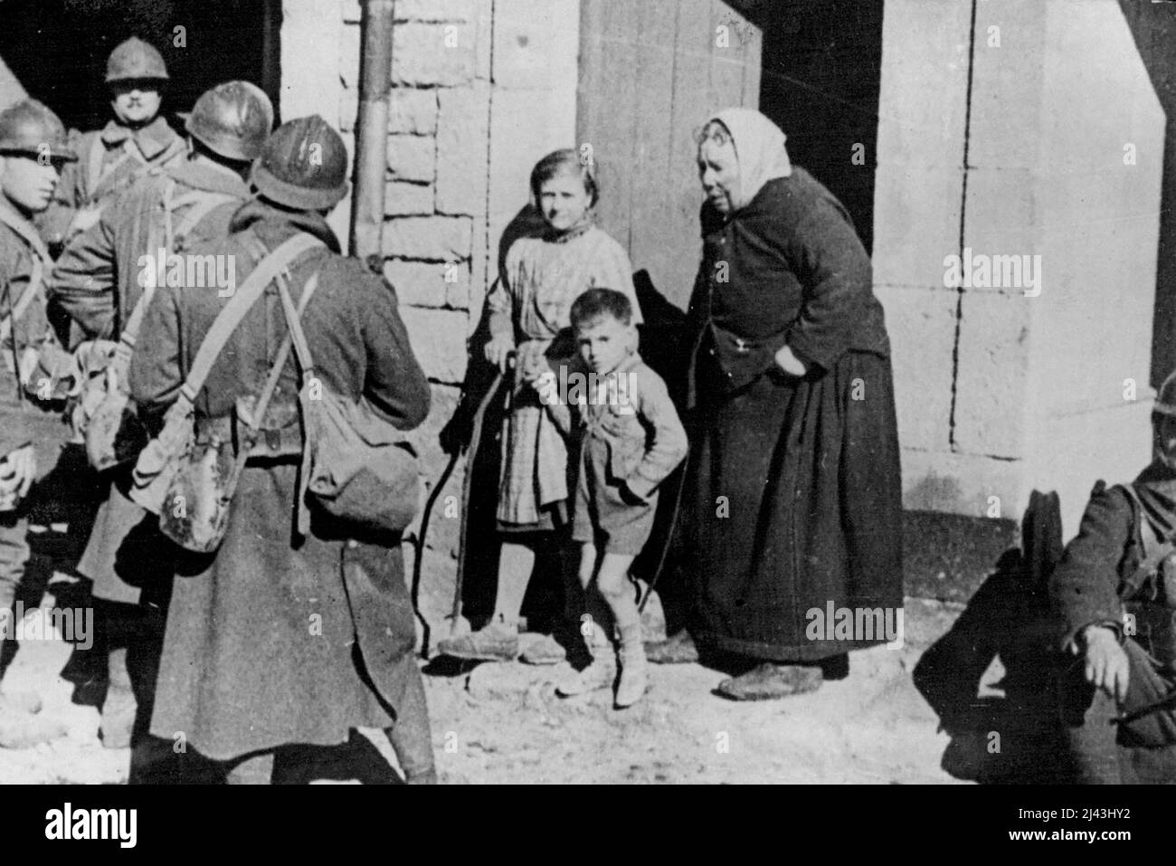 With The French Troops in Germany: An old German peasant woman and her grand children watching French soldiers who captured her village. October 14, 1939. (Photo by Keystone). Stock Photo