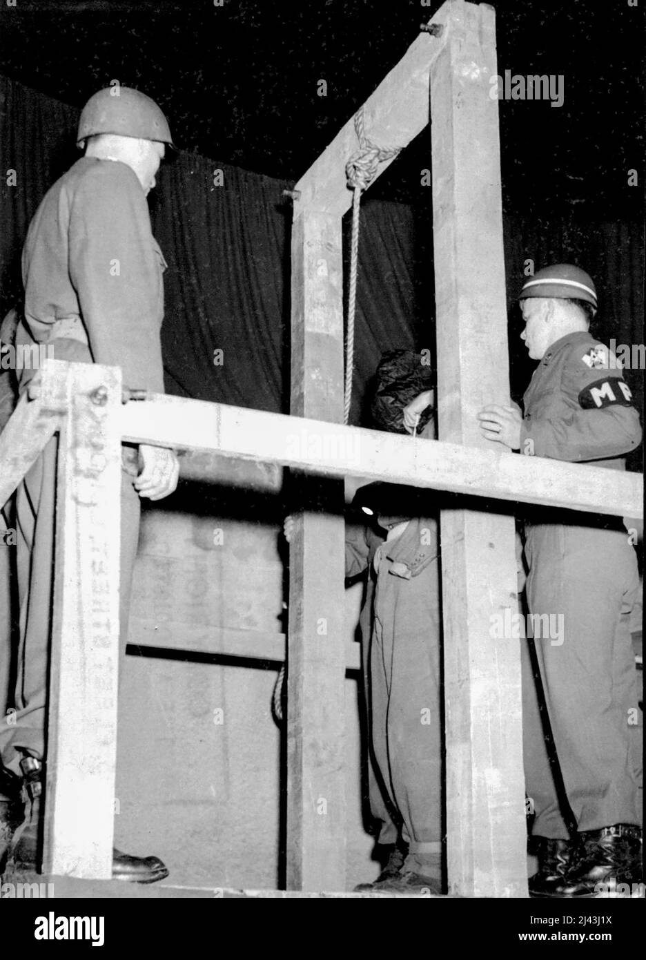 Three German Civilians Executed -- The black hood is placed over the head of Peter Kohn before the execution is carried out. Three German civilians the first war criminals to be tried in Germany, were hanged at dawn today June 29, at the Military prison at Rhineback. All three were found guilty of the murder of American airman who parachute to earth from his blazing bomber last August 15. The three men, Peter back, a cripple and rural leader of the Nazi party; Peter Kohn, one Armed German vetera Stock Photo