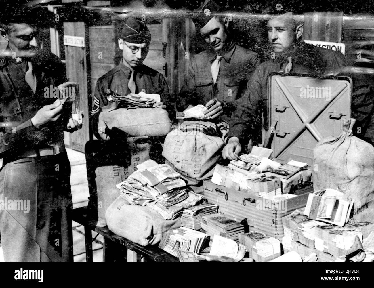 Himmler's Great Money Hoard Discovered -- Himmler's million pound haul being examined by Lt. Col. W.P. Machemehl of Houston, Texas, Chief finance officer of the 101st airborne division. The table is stacked with currency from 26 Nations. Acting on information from a German officer men of the 101st airborne division visited a barn in the vicinity of Berchtsgaden, removed the floorboards and commended to dig. After digging four feet down they game across eleven sacks and a metal case containing p Stock Photo