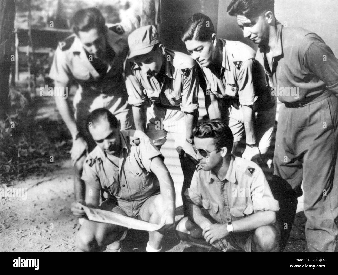 Dutch airmen born in Holland or Netherlands East Indies who fly Mitchell medium bomber aircraft from north-west Australian base avidly read news of the liberation of Holland by Allied forces operating in Europe. Included in group are Lieuts. William A. Murling and Arnold Van der Veen, former students of Breda Military Academy (Holland), Lietus. John Van Peer, of Breda, and Robert de Laive, of The Hague, and Sgt. - Maj. John Kootstra, a former mine worker at Kerkrade, South Holland. January 01, 1945. Stock Photo