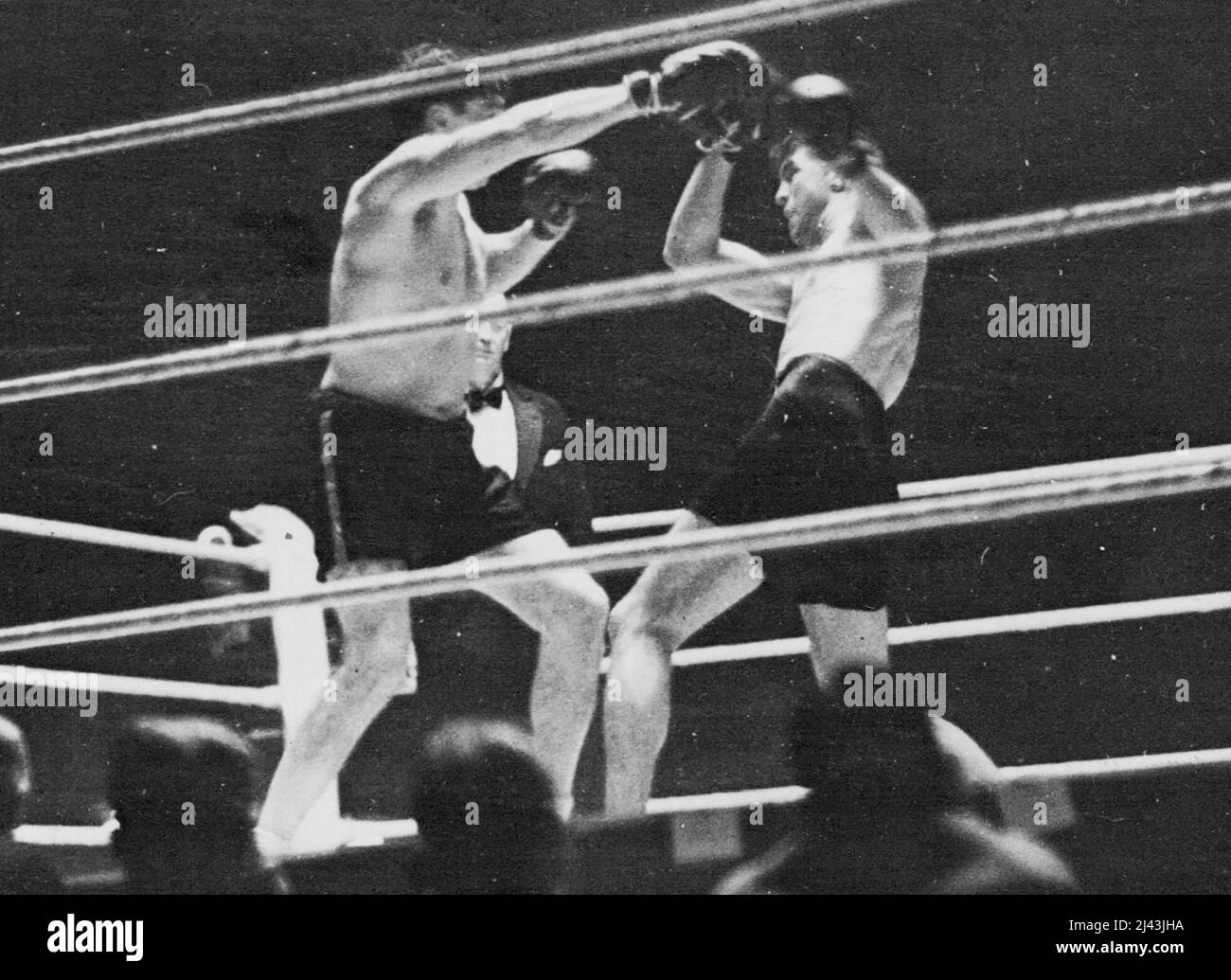 Strickland (right) avoiding a right from Loughran. Tommy Loughran (U.S.A.) beat Maurice Strickland (New Zealand) on points in their bout at the Wembley Pool, London tonight. November 12, 1935. (Photo by The International Graphic Press Ltd.). Stock Photo