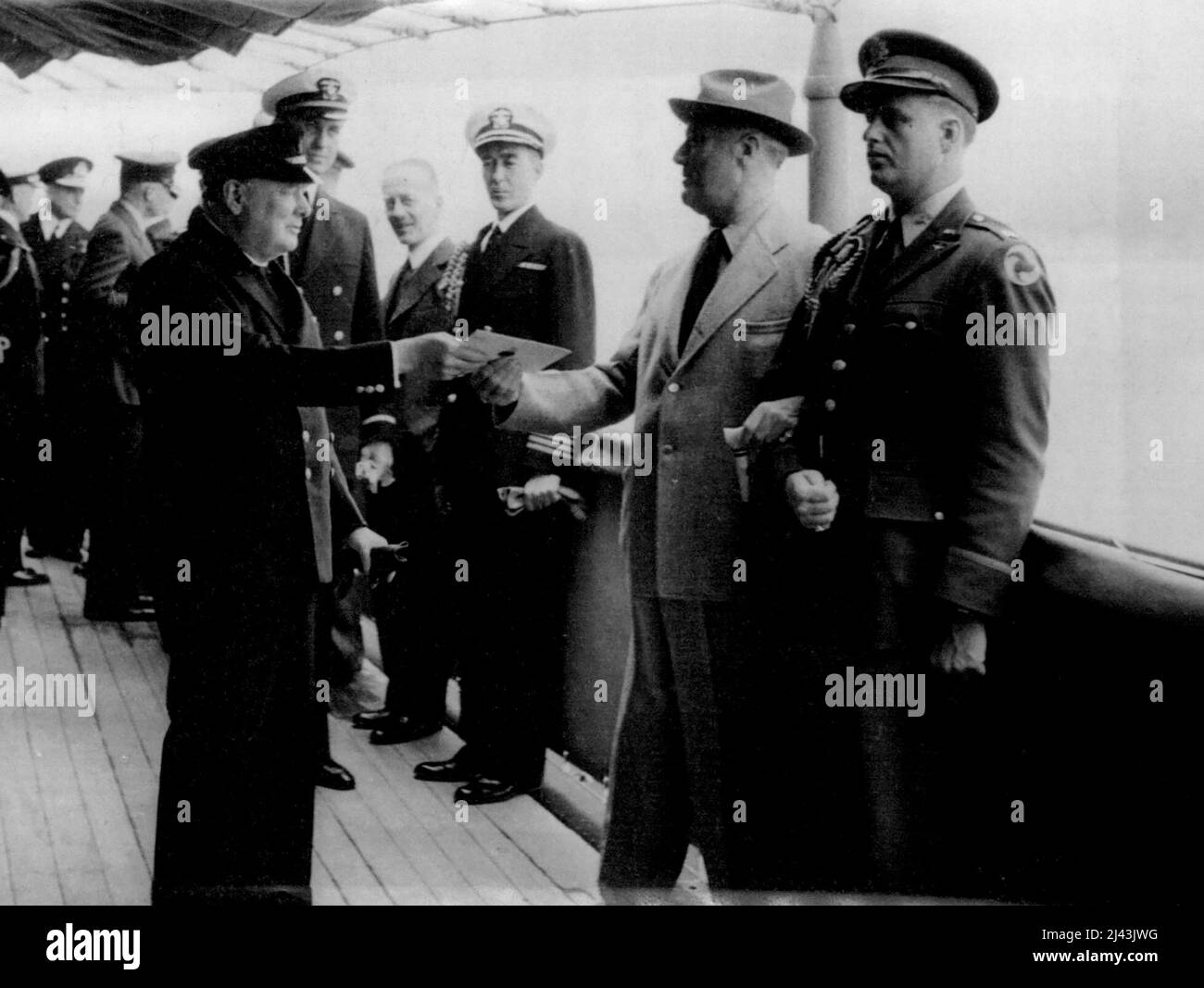 President Meets Prime Minister -- The Prime Minister hands to President Roosevelt aboard the U.S. Cruiser ' Augusta' a personal letter he carried across the Atlantic from H.M. The King. January 1, 1941. (Photo by British Official Photograph). Stock Photo