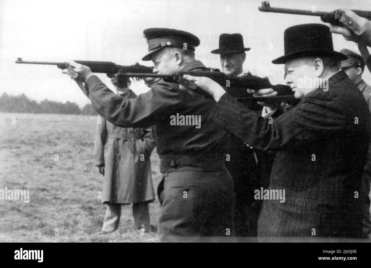 On The Firing Line - Mr. Churchill and General Eisenhower shooting at the target. Allied war chiefs escorting Mr. Churchill on a tour of inspection of American Armoured troops in camps 'Somewhere In England'scored again - This time with the Army's new carbine. With 45 shots between them, and aiming at a target 200 yards away, Mr. Churchill, General Eisenhower and Lt. Gen. Omar N. Bradley scored a total of 29 hits. March 27, 1944. (Photo by U.S.Official Photo). Stock Photo