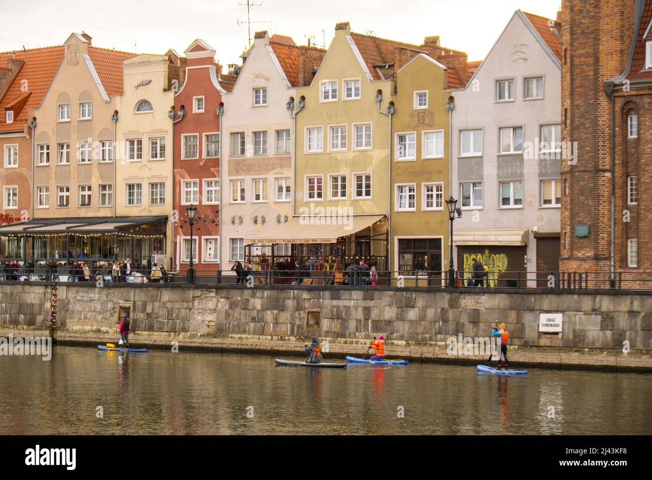 Gdansk Poland March 2022 Group of sup surfers stand up paddle board, women stand  up paddling together in the city Motlawa river and canal in old town Gdansk  Poland. Tourism attraction Active