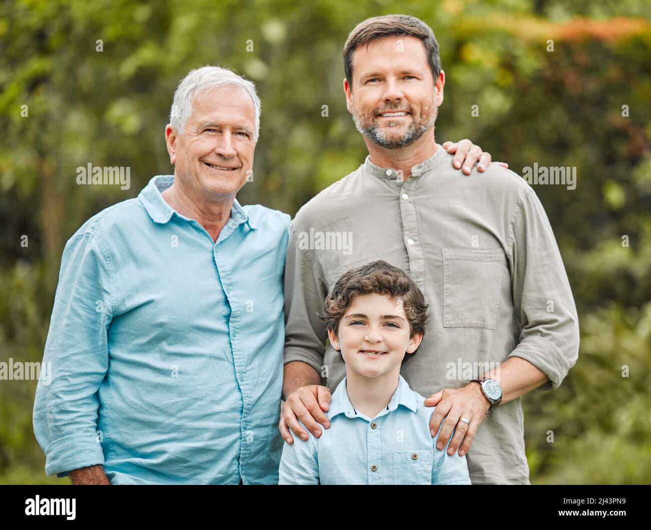 Two and a half men. Shot of a boy standing outside with his father and grandfather. Stock Photo