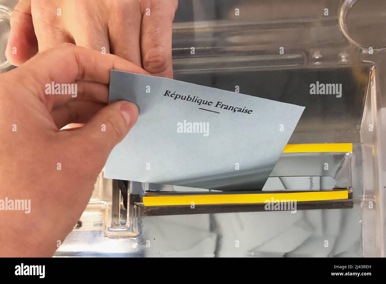 A voter throws an envelope with a candidate into the ballot box