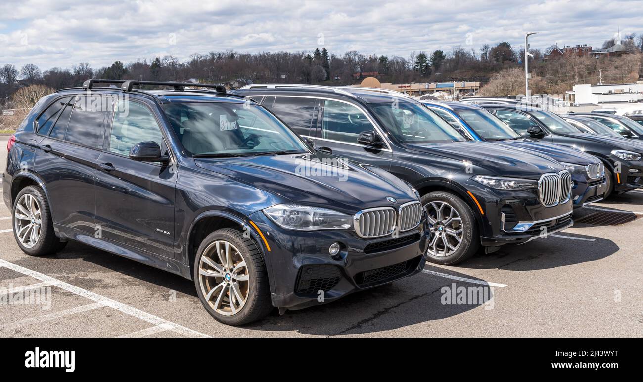 Different BMW SUVs lined up for sale at a dealership in Monroeville