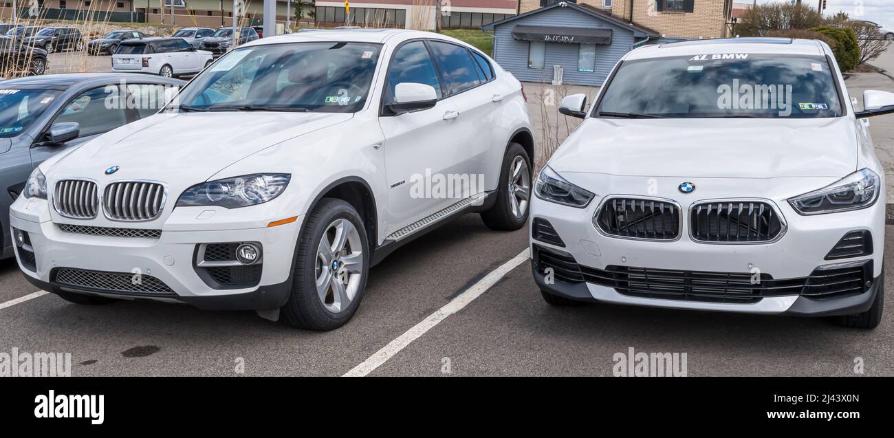 Two different models of white BMW vehicles for sale at a dealership in