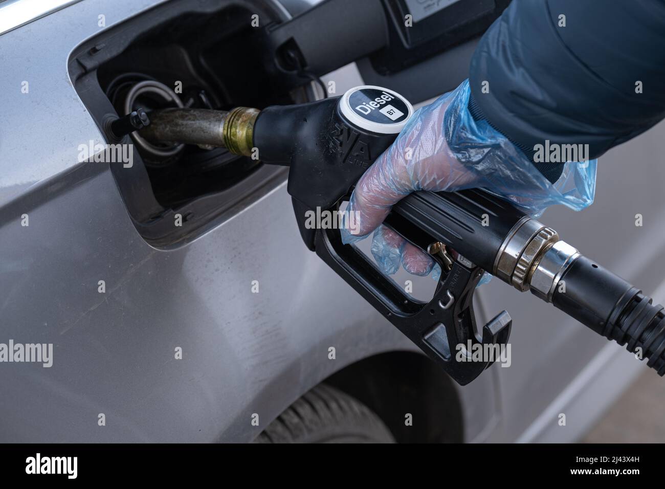 Diesel. Refueling the car.Refueling pistol in the hands of a man in a glove.A man fills up a car tank  Stock Photo