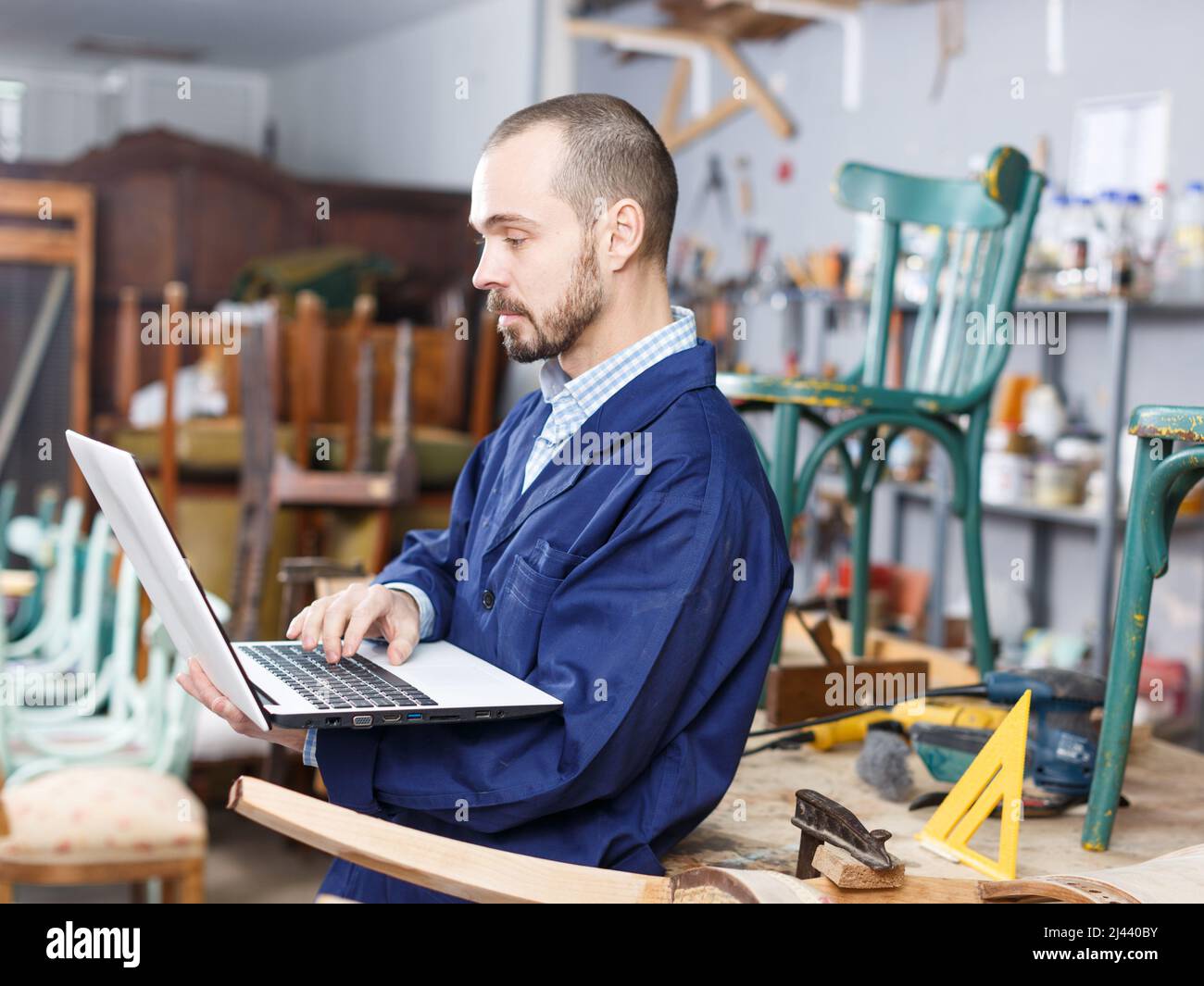 Carpenter using laptop in workshop Stock Photo