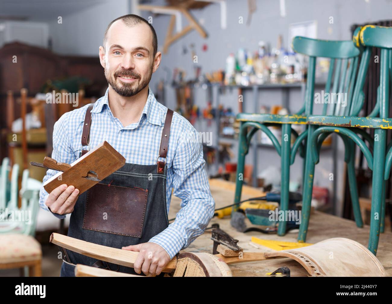 Carpenter standing in furniture repair shop Stock Photo