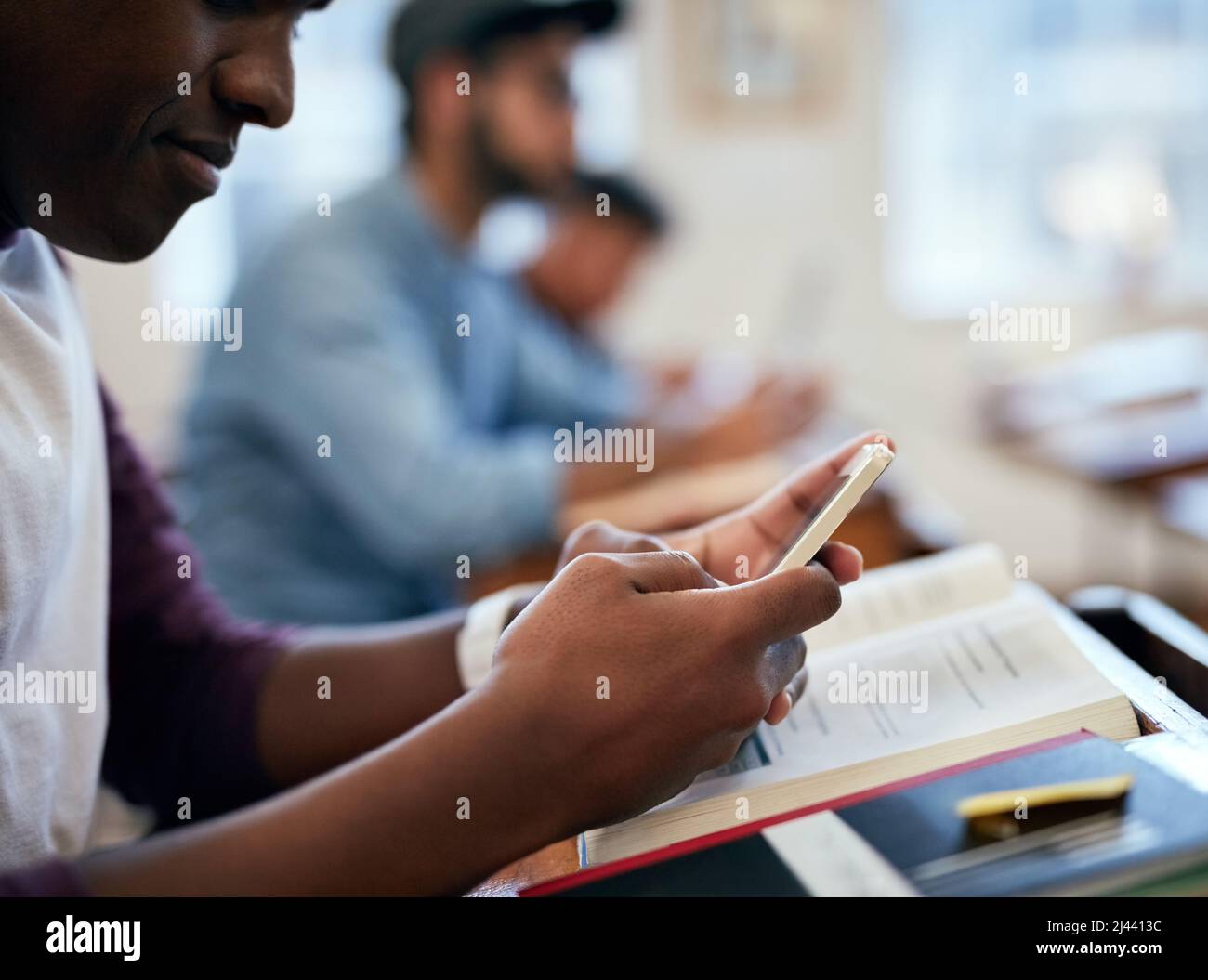 He loves that he can check his answers straight away. Cropped shot of university students using their smartphones in class. Stock Photo