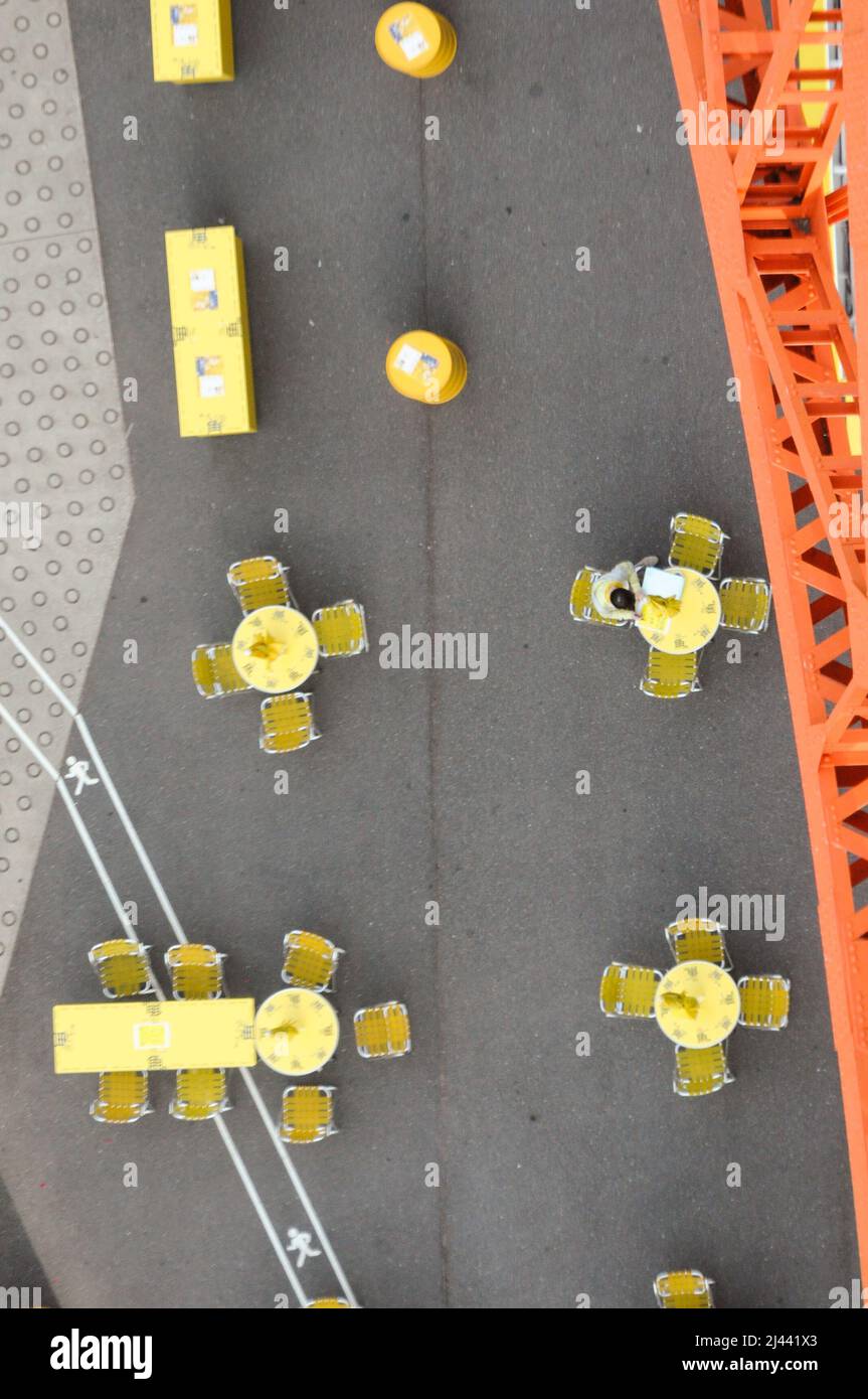 Aerial shot of yellow tables and chairs placed outside Stock Photo