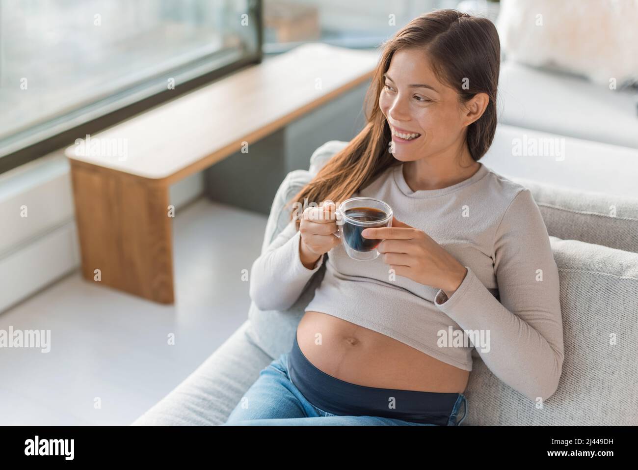 Asian pregnant woman drinking coffee cup at home. Pregnancy foods and