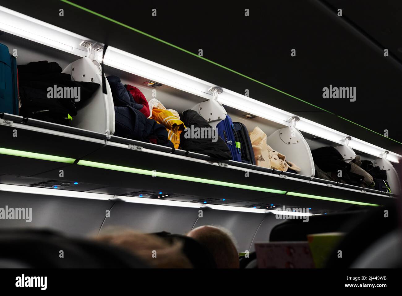 Luggage racks on the plane with luggage before departure of the aircraft. Front view. Stock Photo