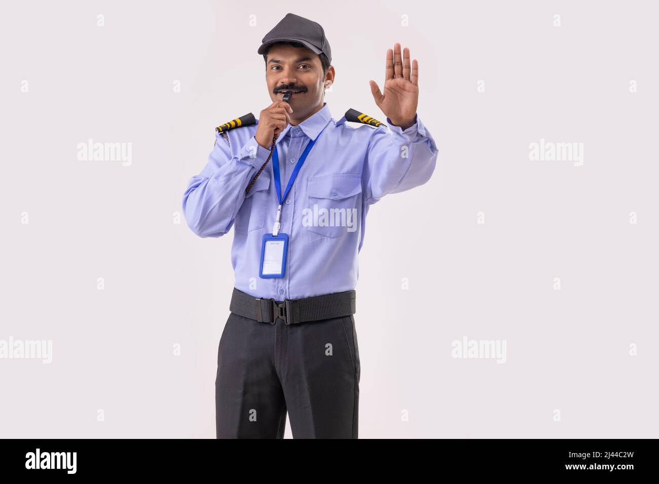 Portrait of Security guard blowing whistle and gesturing with palm