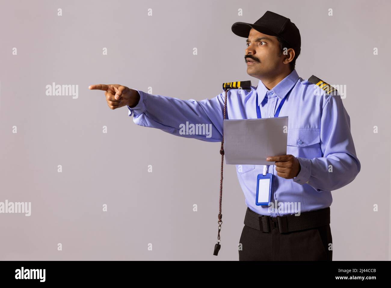Portrait of security guard pointing away with index finger Stock Photo