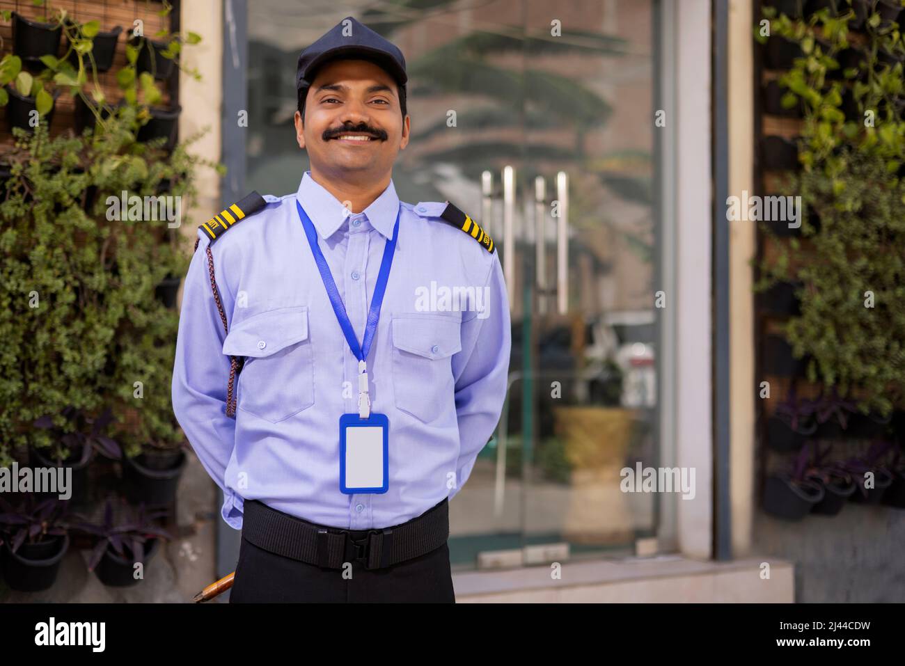 Portrait of security guard with hands behind back while working at gate Stock Photo