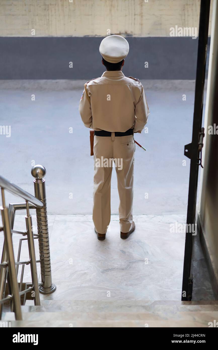 Back view of an Indian Policeman standing at gate Stock Photo