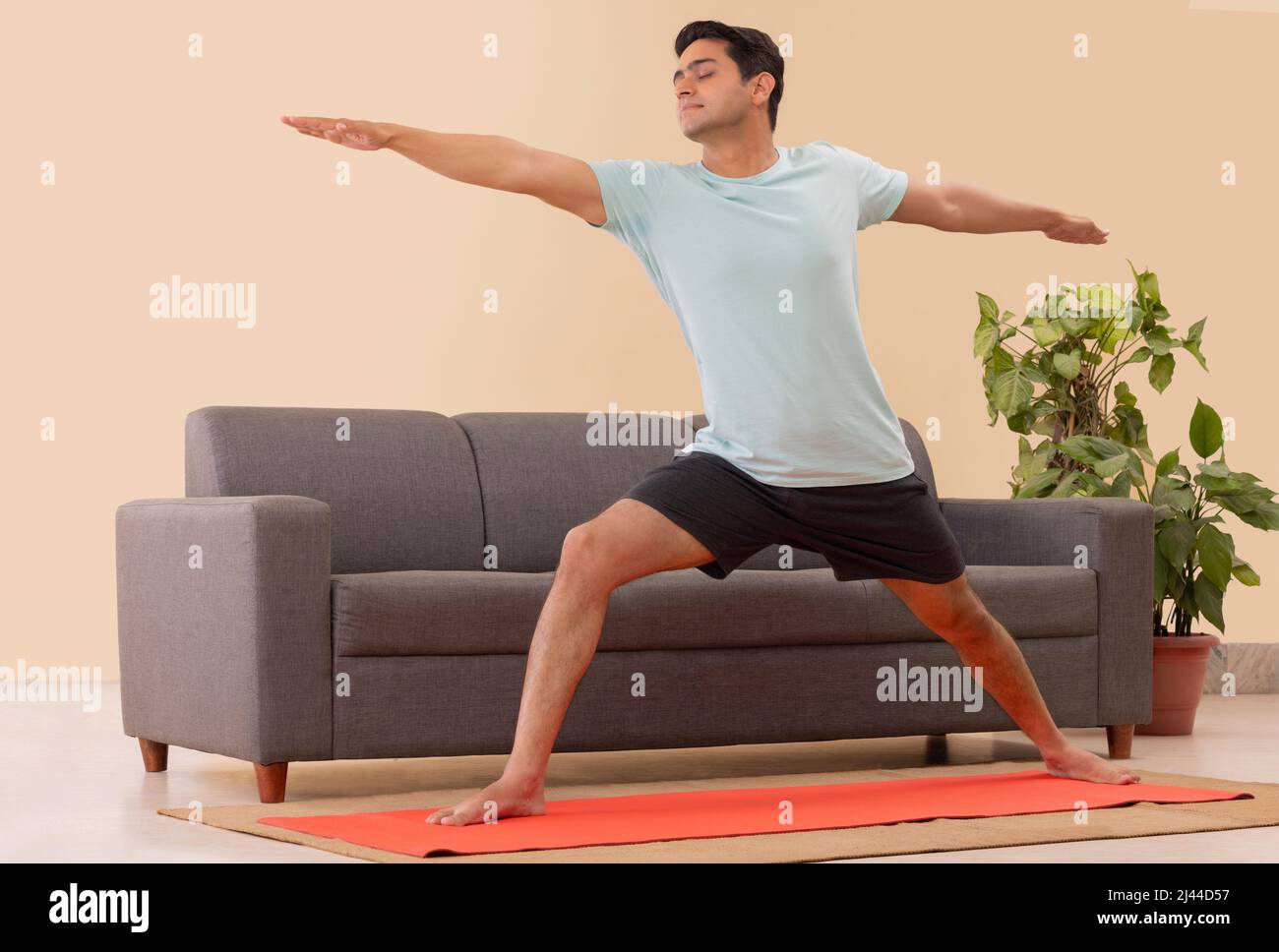 Male Indian Yoga instructor conducting an online class with laptop Stock Photo