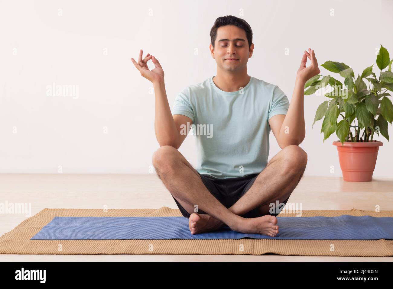 Portrait of a young man meditating at home Stock Photo