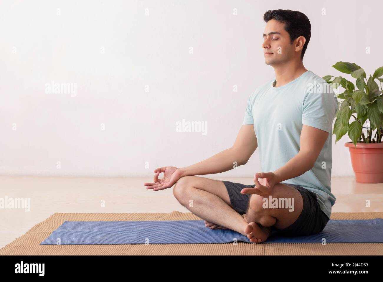 Portrait of a young man meditating at home Stock Photo