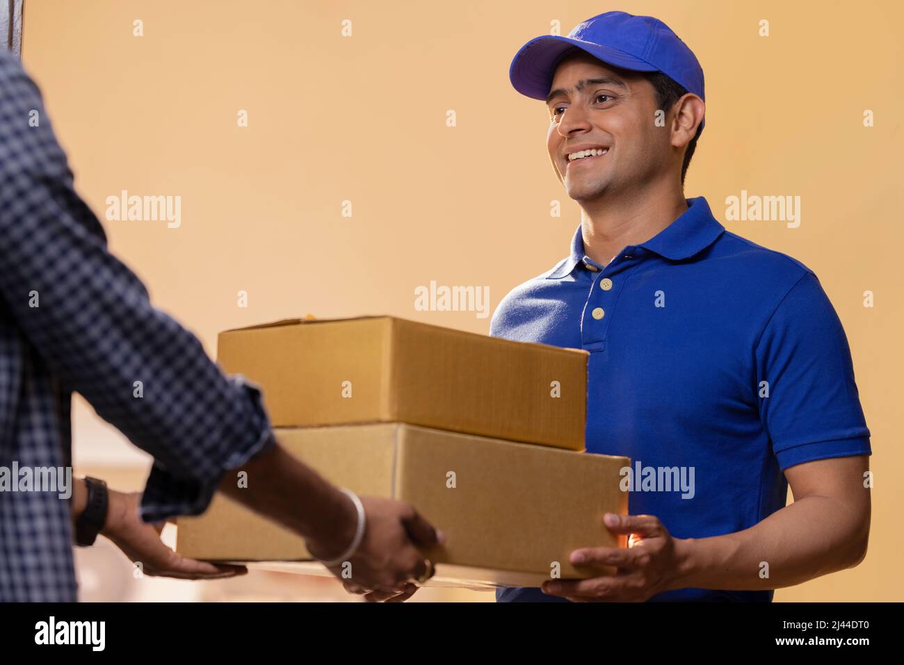 Young courier boy delivery parcels to customer at door Stock Photo Alamy
