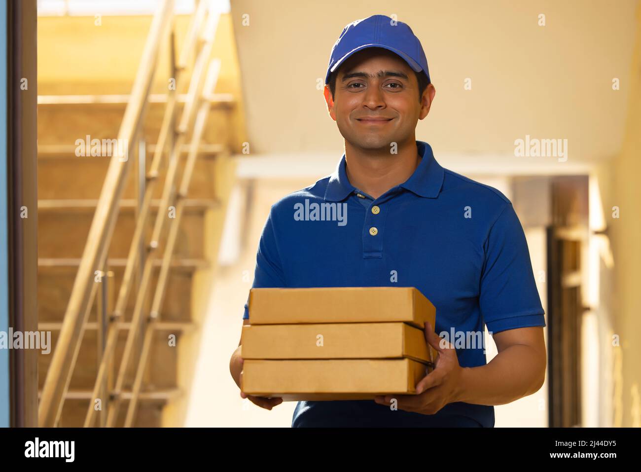 Portrait of courier delivery boy with parcels in his hand Stock Photo