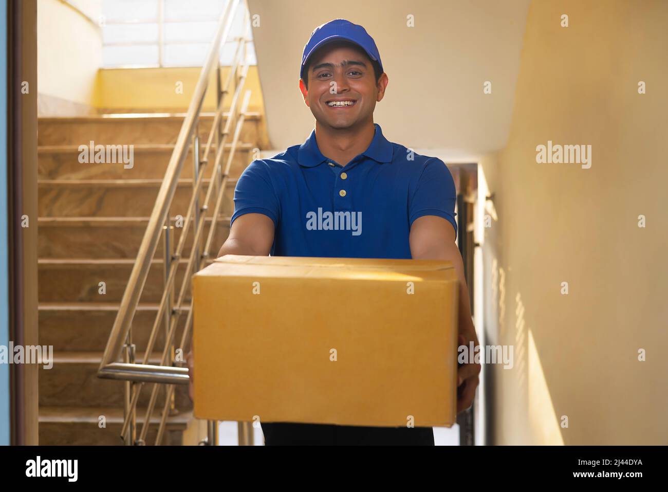 Portrait of courier delivery boy with parcels in his hand Stock Photo