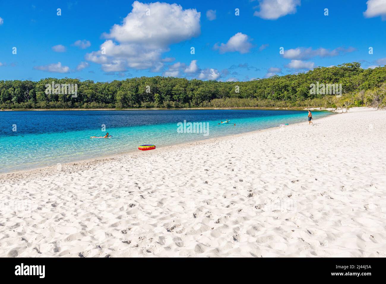 Tourists swim in the crystal clear water at Lake McKenzie on Fraser Island in Queensland, Australia Stock Photo