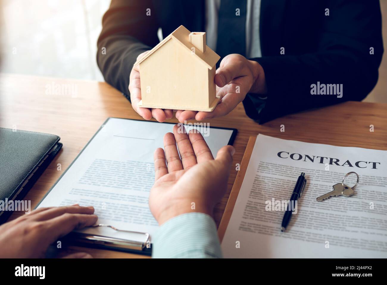 Real estate agent congratulations to new buyer by giving house model to ...